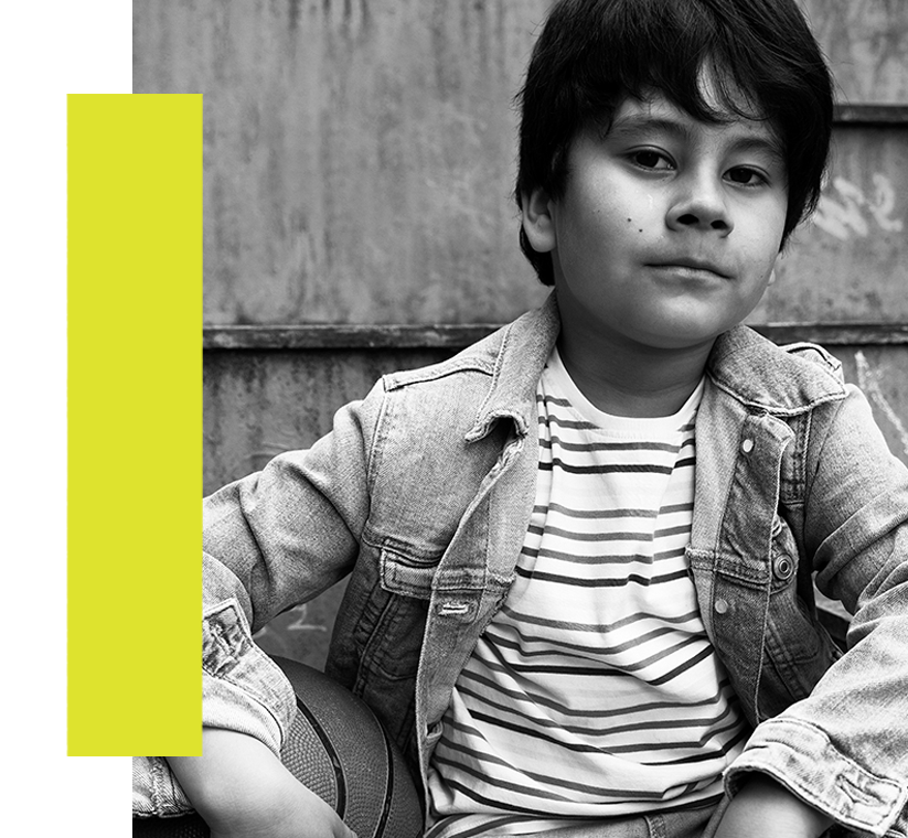 Image of a young Latino man wearing a striped shirt and jean jacket.